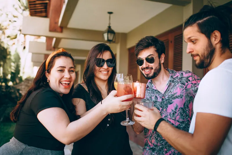 Un gruppo di amici brinda con drink all'aperto a una festa