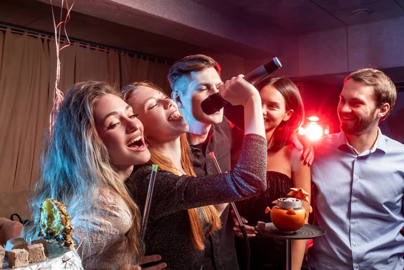 Amici cantano insieme al karaoke a una festa privata
