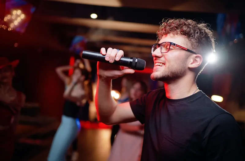 Un giovane canta al karaoke a una festa di compleanno